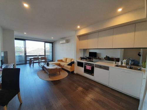 a kitchen and living room with a couch and a table at MHYL Cosy Townhouse in Richmond 1 parking in Melbourne
