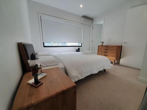 a bedroom with a large white bed and a window at MHYL Cosy Townhouse in Richmond 1 parking in Melbourne