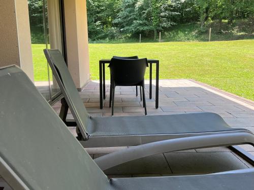 a chair and a table and chairs on a patio at Cal Cisteller in Santa Pau
