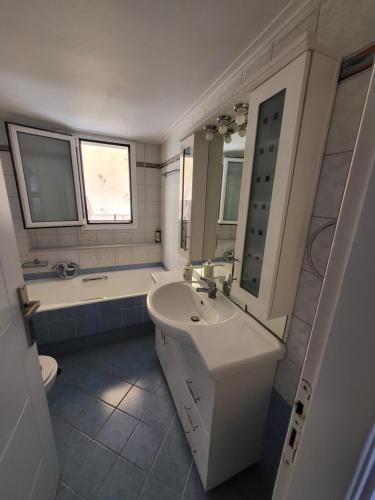a bathroom with a sink and a tub and a toilet at Διαμέρισμα "LENIA" μπροστά στην θάλασσα! in Kiaton