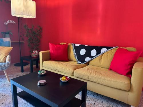 a living room with a couch with red walls at Casa Capanna in Bugnara