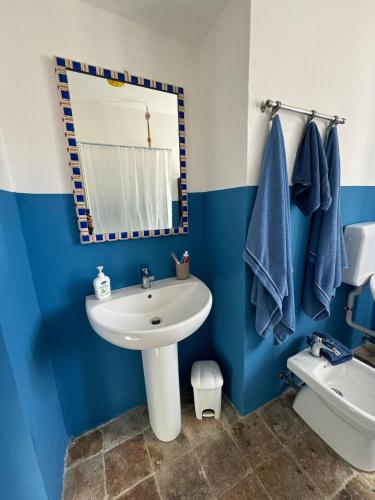 a blue and white bathroom with a sink and a mirror at Casa Capanna in Bugnara