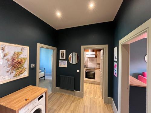 a room with black walls and a kitchen and a hallway at Townhead Jewel by Coorie Doon Stays in Paisley