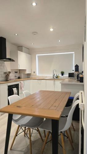 a kitchen with a wooden table and white cabinets at Grace's Place in Littleport in Littleport