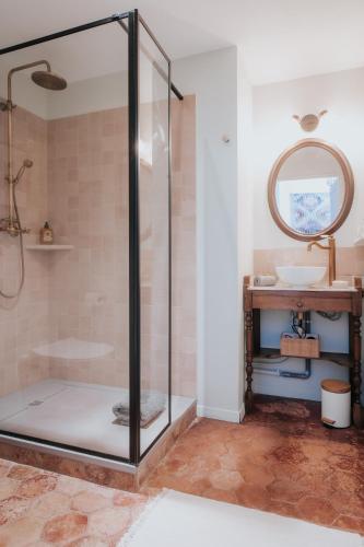 une douche en verre dans une salle de bain avec un lavabo dans l'établissement La Vieille Ferme de Tassigny, à Meursault