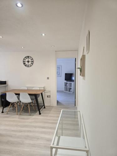 a dining room with a table and a clock on the wall at Grace's Place in Littleport in Littleport