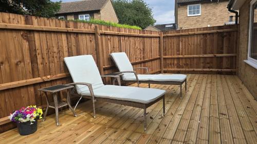 two chairs on a deck with a fence at Grace's Place in Littleport in Littleport