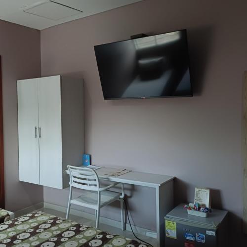 a desk with a chair and a tv on a wall at Hotel Santa Clara Boutique in Montería