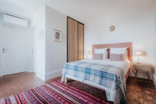 une chambre avec un grand lit et un tapis dans l'établissement La Vieille Ferme de Tassigny, à Meursault