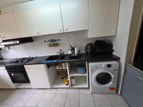 a kitchen with a sink and a washing machine at SE23 Rooms & Beds in London