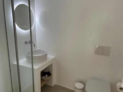 a bathroom with a sink and a toilet and a mirror at ANDELIAS Signature Suites in Chora Folegandros