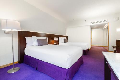 a hotel room with two beds with purple carpet at Camino Real Polanco Mexico in Mexico City