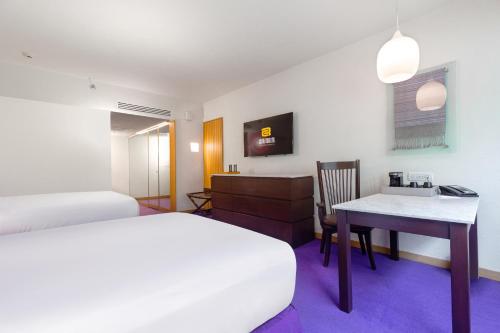 a hotel room with a bed and a desk and a bed and a table at Camino Real Polanco Mexico in Mexico City
