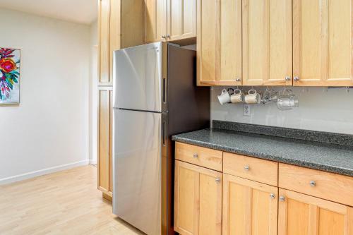 a kitchen with a refrigerator and wooden cabinets at Spring-Fed Soaking Tub! Lush Central Oregon Haven in McKenzie Bridge
