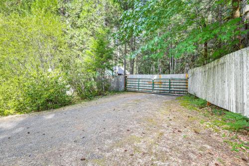 a driveway with a fence in front of a house at Spring-Fed Soaking Tub! Lush Central Oregon Haven in McKenzie Bridge