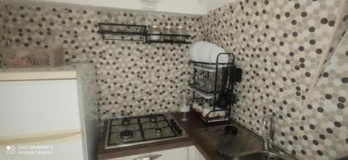 a kitchen with a stove and a sink and a patterned wall at Casa MiKiaMi in Monte SantʼAngelo