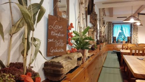 a restaurant with tables and plants on the wall at Kachelofa GbR in Vaihingen an der Enz