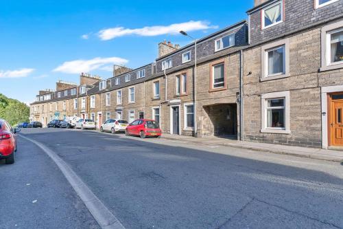 a street with cars parked on the side of the road at Vacant Nest Central Location Wifi & Shops in Hawick
