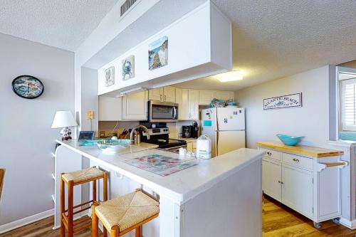 a kitchen with white cabinets and a white refrigerator at Sands Villa 419 in Atlantic Beach