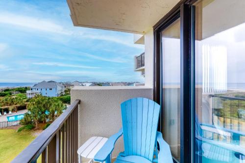 a blue chair on a balcony with a view of the ocean at Sands Villa 419 in Atlantic Beach