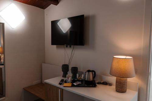 a desk with a lamp and a tv on a wall at Vacanze da Beppuccio Scoglitti in Vittoria