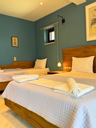 two beds in a room with blue walls at Armenopetra View Gerolimenas in Gerolimenas