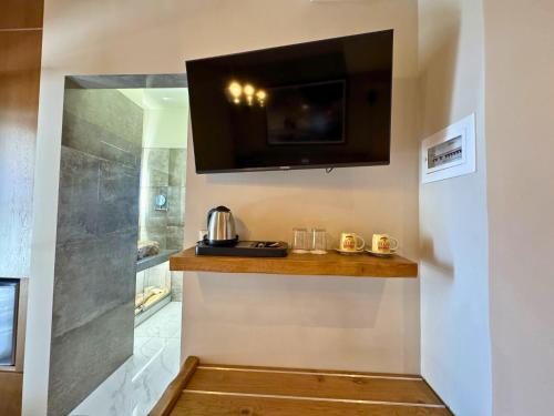 a bathroom with a television on a wall with a counter at Armenopetra View Gerolimenas in Gerolimenas