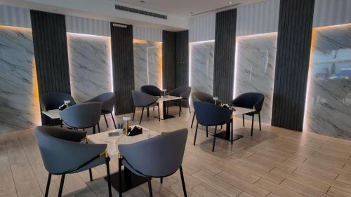 a restaurant with tables and chairs and marble walls at Milan Park Hotel in Taif