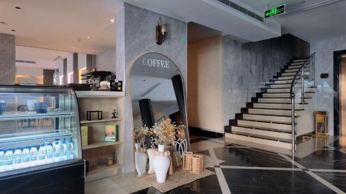 a lobby with a coffee shop and a staircase at Milan Park Hotel in Taif