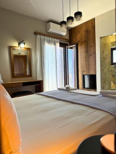 a bedroom with a large white bed with a window at Armenopetra View Gerolimenas in Gerolimenas