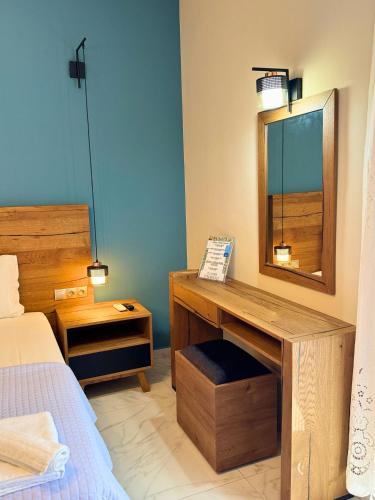 a bedroom with a bed and a desk with a mirror at Armenopetra View Gerolimenas in Gerolimenas