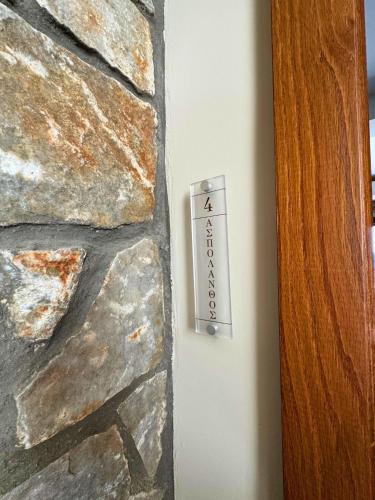 a thermometer on the side of a stone wall at Armenopetra View Gerolimenas in Gerolimenas