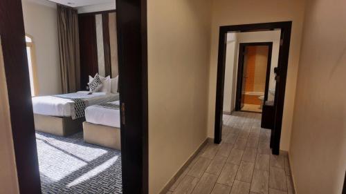 a view of a bedroom with two beds and a mirror at Milan Park Hotel in Taif