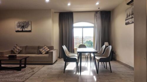 a living room with a table and chairs and a couch at Milan Park Hotel in Taif