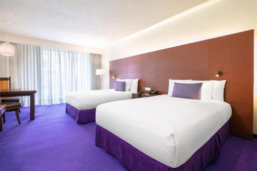 a hotel room with two beds and a table at Camino Real Polanco Mexico in Mexico City