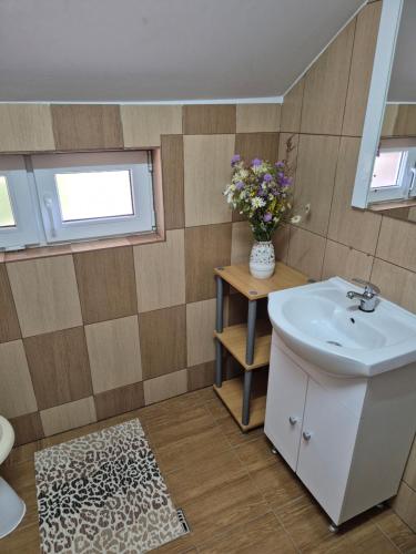 un bagno con un lavandino e un vaso di fiori di Kings Valley Retreat Apuseni Mountains a Câmpeni