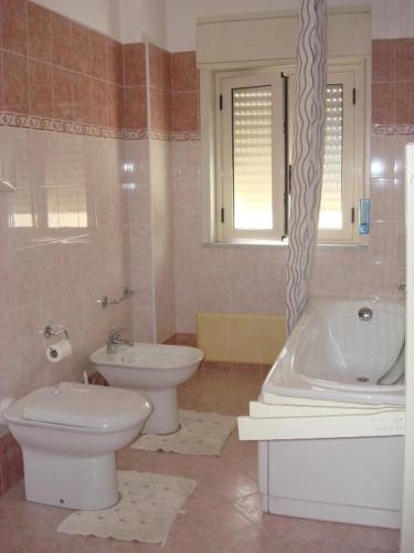 a bathroom with a toilet and a tub and a sink at B&B Emmanuel2 in Reggio Calabria