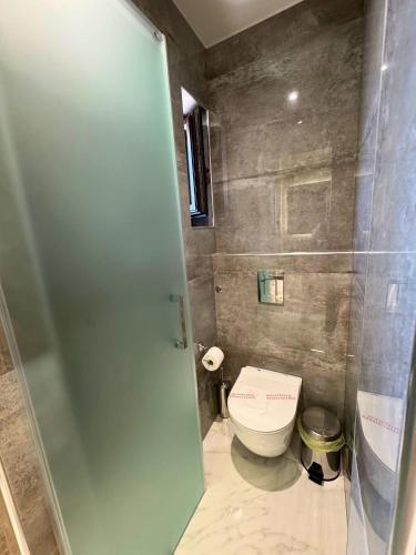 a bathroom with a toilet and a glass door at Armenopetra View Gerolimenas in Gerolimenas