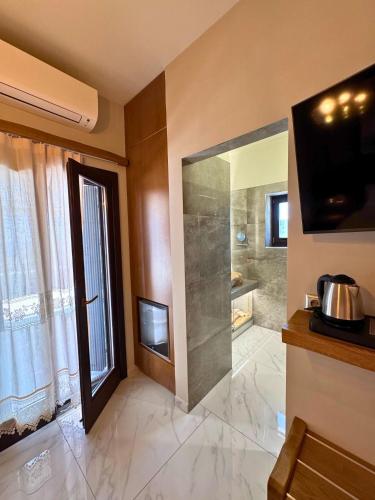 a bathroom with a shower and a large glass door at Armenopetra View Gerolimenas in Gerolimenas