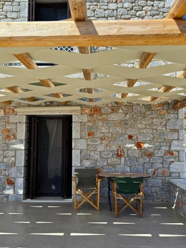 a patio with a table and chairs under a wooden ceiling at Armenopetra View Gerolimenas in Gerolimenas