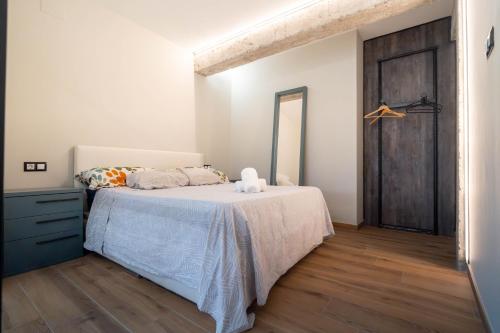 a bedroom with a bed and a wooden floor at Apartamento Vermú in Guadix
