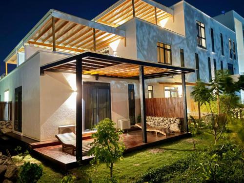 a house with a wooden deck in front of it at 1 BDR Garden Apartment at The Soul, Paje in Paje