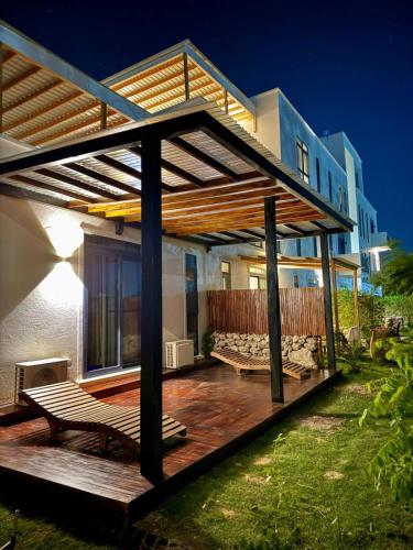 a house with a wooden deck in the yard at 1 BDR Garden Apartment at The Soul, Paje in Paje