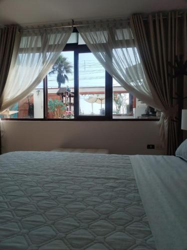 ein Schlafzimmer mit einem Bett und einem großen Fenster in der Unterkunft Departamento luminoso frente de la playa Huanchaco in Huanchaco