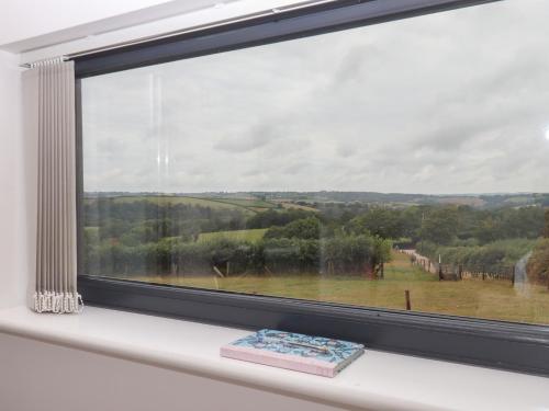 a window with a book on a white window sill at The Bickleigh in Tiverton