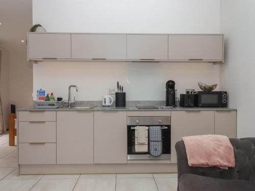 a kitchen with white cabinets and a sink at The Bickleigh in Tiverton