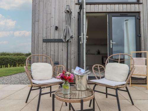 two chairs and a table with flowers on a patio at The Bickleigh in Tiverton