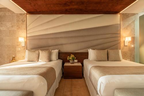 two beds in a hotel room with two beds sidx sidx sidx at Villas Caracol in Holbox Island