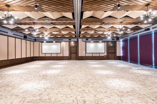 an empty room with a large hall with wooden ceilings at Aloft Tulum in Tulum