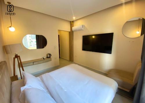 a bedroom with a bed and a flat screen tv at Hayah Waterfalls Hotels in Alexandria